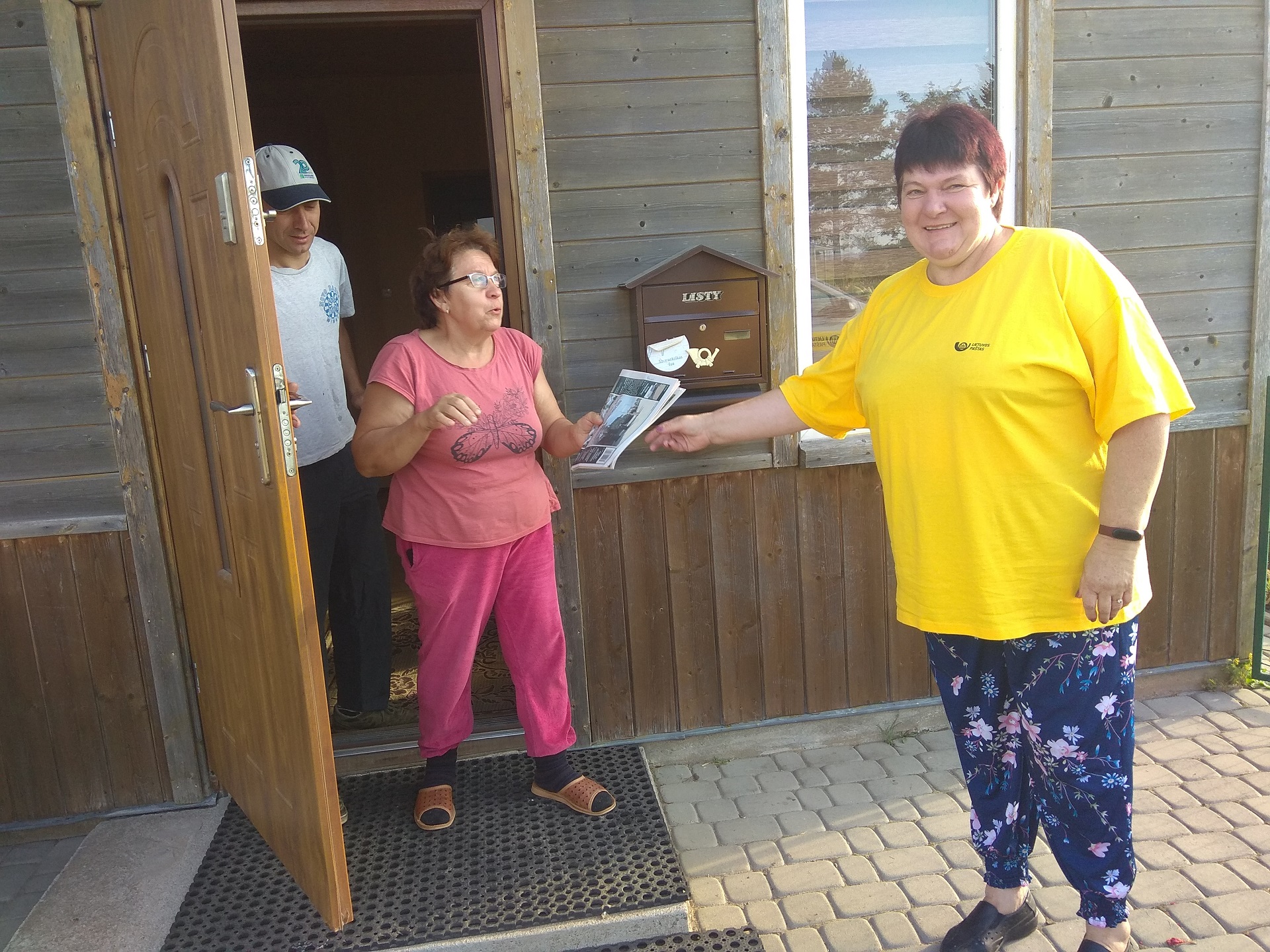 Užsukame į vienkiemį, kur daugybę metų gyvena ponia Danutė. Moteris su šypsena pasitinka laiškininkę ir padėkoja jai už atneštą laikraštį./Dimitrijaus Kuprijanovo nuotr.
