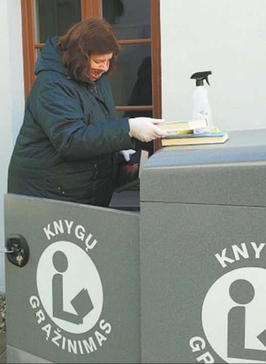 Susikaupusias knygas mūvėdamos pirštines bibliotekininkės išima iš dėžių. Dėžes dezinfekuoja ir maždaug savaitę laiko vėdinamoje patalpoje.