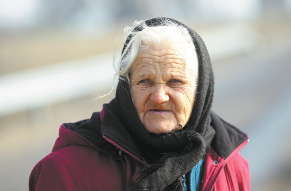 Netrukus pamatome ir su kibiru rankose keliaujančią močiutę. Tai ponia Janina, Tiskūnų kaime gyventi visą savo gyvenimą. A. Barzdžiaus nuotr. 