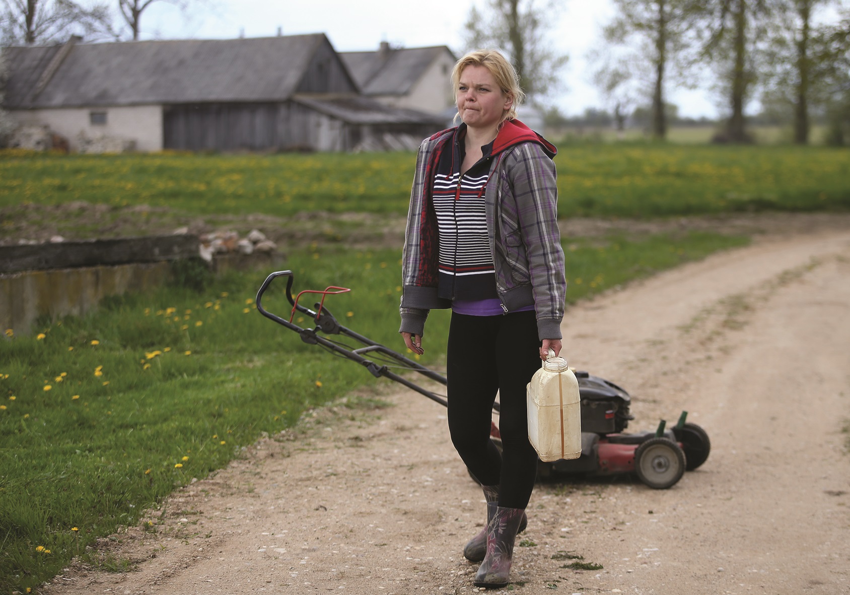 Atvykus į kaimą akys pirmiausia užkliūva už šimtamečio dvaro. Užsukame į jį ir nustembame – jauna mergina pjauna didžiulį plotą žolės, tai – Erna, mergina, gyvenanti dvare./ A. Barzdžiaus nuotr.